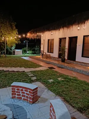a house with a brick pillar in the yard at night at Forest Brew Resort Wayanad in Chekadi