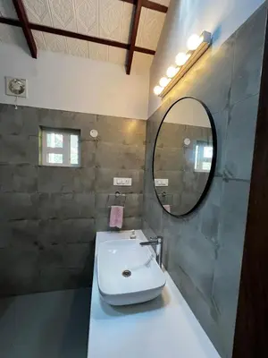 a bathroom with a sink and a mirror at Birdsong Coffee Estate Stay in Madikeri