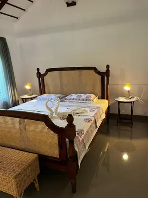 a bedroom with a bed with a swan on it at Birdsong Coffee Estate Stay in Madikeri