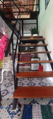a set of wooden stairs in a room with a rug at WellGrown- The Farmhouse at Kombai - Pallangi, Kodaikanal in Kodaikānāl