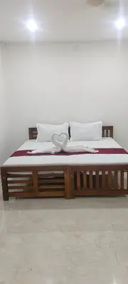 a large bed with a wooden frame in a room at VKJ Lodge in Alwaye