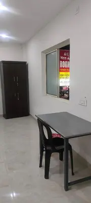 a black table and a chair in a room at VKJ Lodge in Alwaye