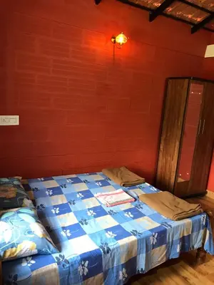 a bed in a room with a red wall at Snow Drop Villa in Gonikoppal