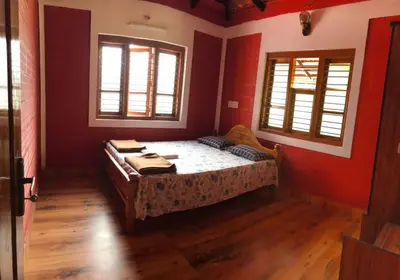 a bedroom with a bed and two windows at Snow Drop Villa in Gonikoppal