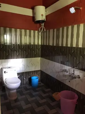 a bathroom with a toilet and a sink at Snow Drop Villa in Gonikoppal