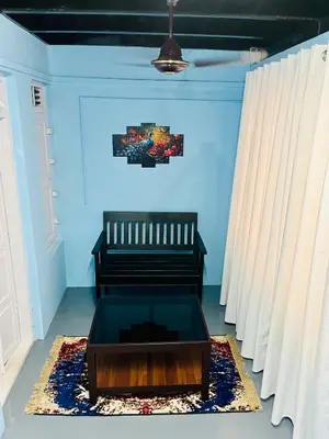 a living room with a bench and a table at Arapura Veedu Heritage Homestay in Kizhillam