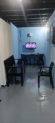a room with chairs and a table and a tv at Arapura Veedu Heritage Homestay in Kizhillam