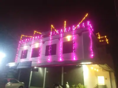 a building with pink lights on top of it at night at Tour Way Nadavayal Inn in Kenichira