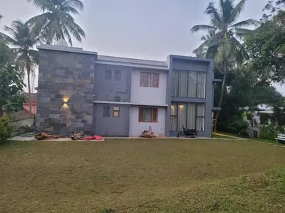 a house with a large yard in front of it at Aurora The Pool Villa in Kozhikode