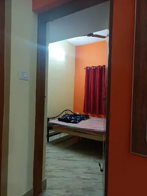 a bedroom with a bed and a red curtain at Holy Family Nest in Mysore
