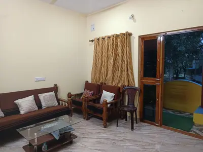 a living room with a couch and chairs and a table at Holy Family Nest in Mysore