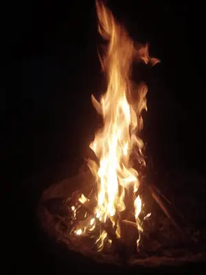 a fire is burning in the dark at Varshinicottage kothkiri in Kotagiri