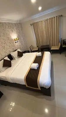 a bedroom with a large bed with towels on it at Hotel Grand Regency, Angamaly in Angamali