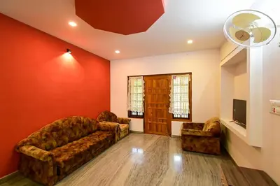 a living room with two couches and a tv at San WAYANAD HOMESTAY AND SERVICE VILLA in Sultan Bathery