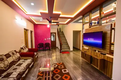 a living room with a couch and a flat screen tv at San WAYANAD HOMESTAY AND SERVICE VILLA in Sultan Bathery