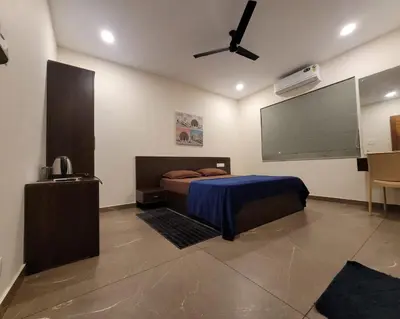 a bedroom with a bed and a flat screen tv at Aurora The Pool Villa ll in Kozhikode