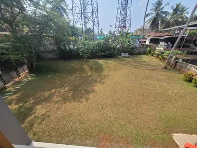 a large yard with grass and trees and a fence at Aurora The Pool Villa ll in Kozhikode