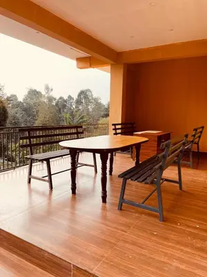 a table and two benches sitting on a balcony at Elegant Mountain Resort in Kalpetta