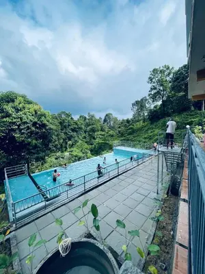 a group of people in a swimming pool at Elegant Mountain Resort in Kalpetta