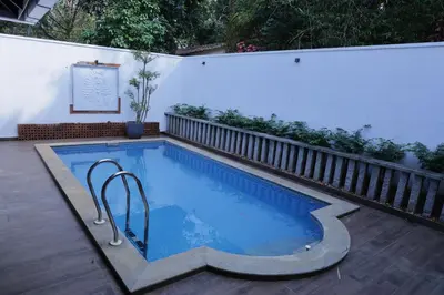 a small swimming pool in a backyard with a fence at Hortus Malabaricus Garden Resort in Cheruthuruthi