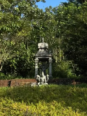 a statue in the middle of a garden at Hortus Malabaricus Garden Resort in Cheruthuruthi