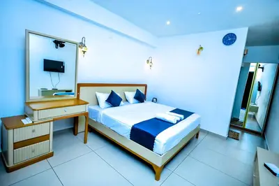 a bedroom with a bed and a dresser and a mirror at La Vista Resorts in Wayanad