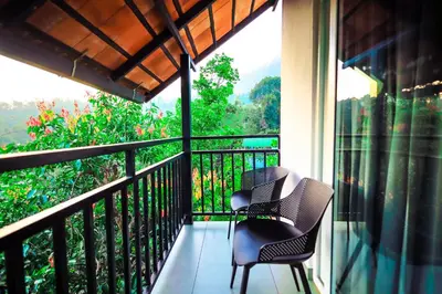 two chairs on a balcony with a view of the mountains at La Vista Resorts in Wayanad