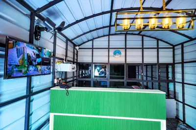 a bar with a green counter and a tv at La Vista Resorts in Wayanad