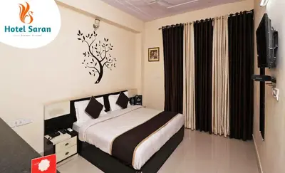a hotel room with a bed and a television at Hotel Saran Palani in Palani