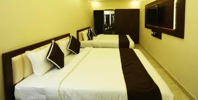 two beds in a hotel room with two beds sidx sidx sidx at Hotel Saran Palani in Palani