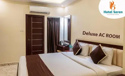 a hotel room with a bed and a welcome ac room sign at Hotel Saran Palani in Palani