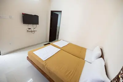 a bedroom with a bed and a tv on the wall at Viba Residency in Coimbatore