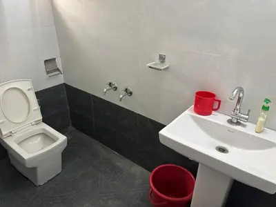 a bathroom with a white toilet and a sink at Heart of Mysore - Entire Place for yourself in Mysore