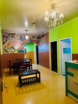 a dining room with a table and a colorful wall at Greenwoods Munnar Unmarried Allowed in Munnar