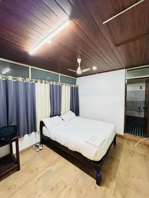 a bedroom with a bed in a room at Greenwoods Munnar Unmarried Allowed in Munnar
