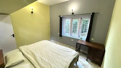 a small bedroom with a bed and a window at Away From Home - 1 - Rooms In Ooty, Home Stay Ooty in Ooty
