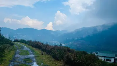 a winding road on a hill with mountains in the background at Away From Home - 1 - Rooms In Ooty, Home Stay Ooty in Ooty
