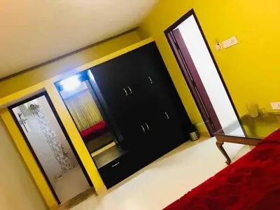 a bedroom with a red bed and a mirror at Greenyard cottage in Ooty