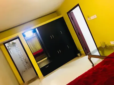 a bedroom with two black cabinets and a mirror at Greenyard cottage in Ooty