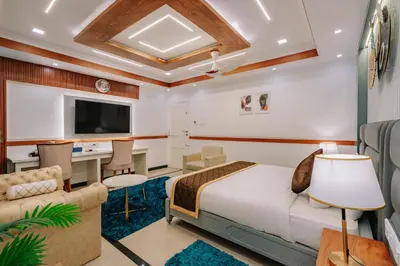 a hotel room with a bed and a desk at Excellency Airport Hotel in Ernakulam