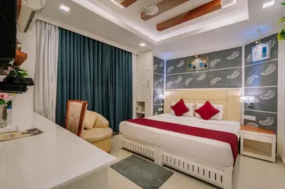a hotel room with a bed with red pillows at Excellency Airport Hotel in Ernakulam