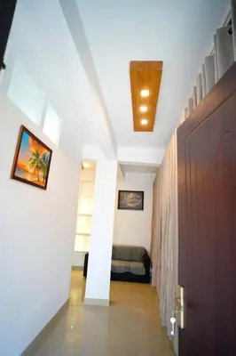 a hallway with a door and a bed in a room at Hr residency in Kozhikode