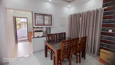 a kitchen and dining room with a table and chairs at Karukutty Rental House in Adūr