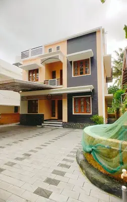 a large house with a driveway in front of it at Karukutty Rental House in Adūr