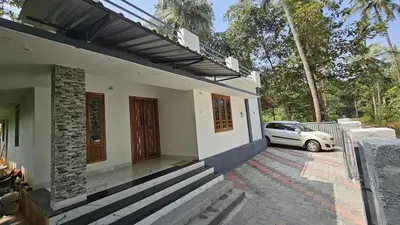 a white car parked outside of a house at In-woods stay in Olavakod Junction