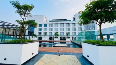 a hotel with two trees in front of a building at Gokulam Grand Kozhikode in Kozhikode