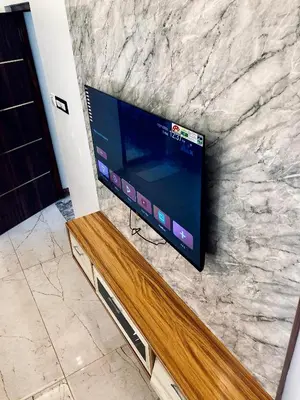 a flat screen tv mounted on a stone wall at Galaxy Garden Resort in Kallār