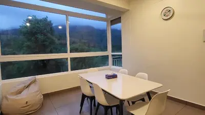 a dining room with a table and chairs and a large window at Mountain Serenity Meppadi, Wayanad in Kalpetta