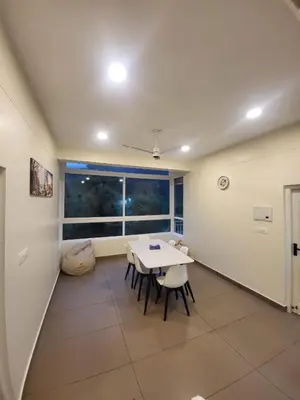 a dining room with a table and chairs and a window at Mountain Serenity Meppadi, Wayanad in Kalpetta