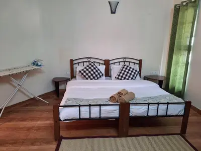 a bedroom with a large bed with white sheets and pillows at Pristine Stay by LexStays in Coonoor